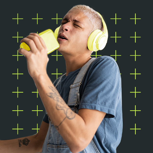 Young adult singing into their phone with headphones on