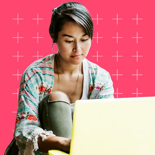 Young adult sitting by laptop