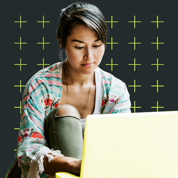 Young adult sitting by laptop